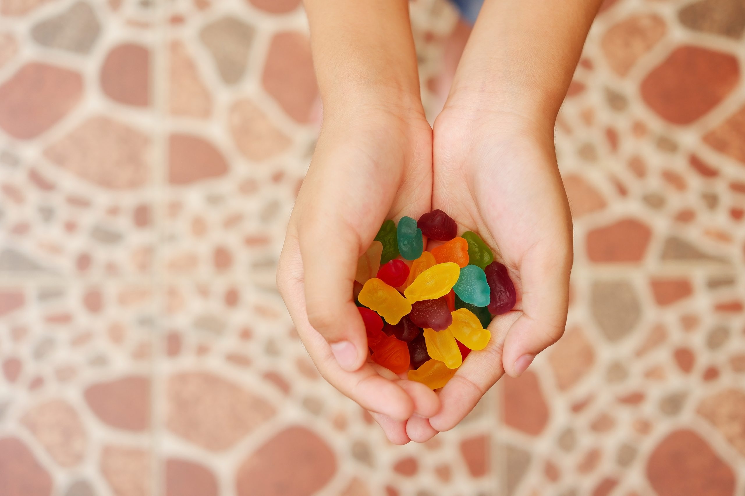 Child’s hand holding colourful gummy jelly Child's hand holding colourful gummy jelly
